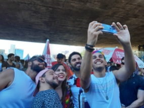 David Miranda und zwei Parteikolleg*innen machen auf der Pride Parade in São Paulo ein Selfie mit Fans